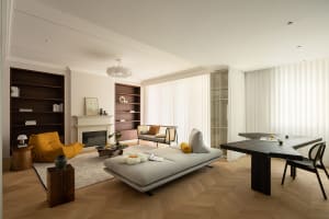 A contemporary living room with a timber floor, featuring modern furniture, a fireplace, and bookshelves.
