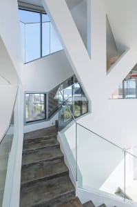 Modern staircase featuring glass, metal, and concrete materials