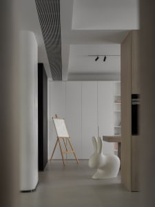 A minimalist art studio featuring a floating wooden table and white panels