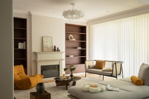 A modern interior design living room with a fireplace, bookshelves, and comfortable seating.