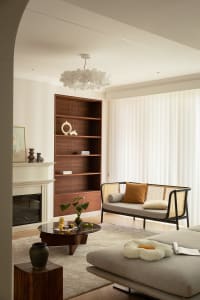 Modern living room featuring a wooden cabinet, woven sofa, and glass coffee table.