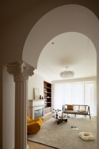 Modern living room with a neutral color palette, featuring a fireplace, a round coffee table, and a comfortable sofa.