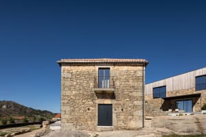 A modern holiday villa featuring a stone exterior and wooden accents.