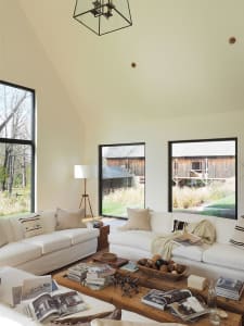 A modern living room with white sofas and wooden coffee table.