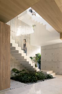 Modern, industrial-style staircase featuring concrete steps, glass railing, and timber finish.