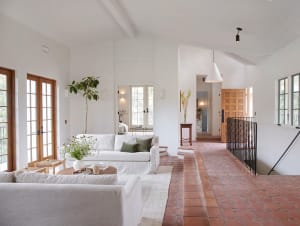 Modern living room featuring terrazzo flooring, white sofas, and large windows.