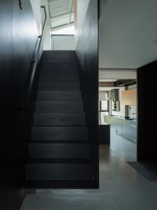 A modern, black metal staircase in a residential interior with a minimalist design.