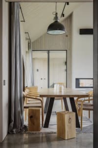 Modern and minimalist residential kitchen with wooden elements and a table.