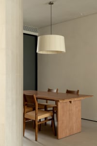Minimalist dining room featuring a wooden table with fabric chairs.