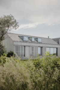 Modern house with metallic siding and transparent roofing panels