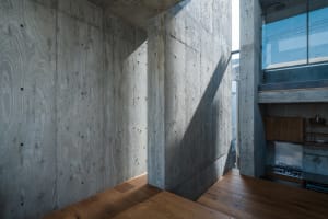 Concrete walls and wooden floor in a minimalist kitchen setting.