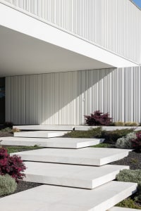 A modern exterior with concrete steps leading up to a building entrance.