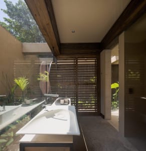 A modern bathroom featuring a sleek, white floating sink with a concrete countertop, situated in a contemporary residential s