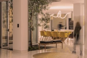 A modern dining room featuring metallic lamp and green plant