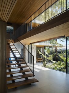 Modern interior space with wooden stairs and large glass windows.