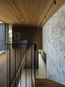 A modern interior with a wooden staircase and terraced walls.
