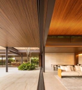 Modern living room with wooden beams, concrete floor, and indoor plant