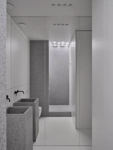 Minimalist grey granite bathroom interior with white floor and black fixtures