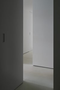 A minimalist interior with concrete walls and flooring.