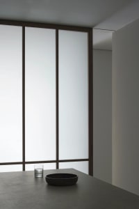 Minimalist room with large windows and glass surfaces.