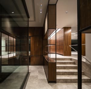 An elegant modern office library features a staircase with wooden panels and marble steps.