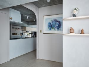 Modern kitchen with minimalist design, concrete countertops, and concrete walls.