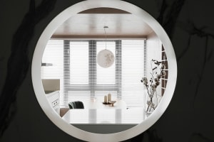 Modern, minimalist residential dining room with white decor and white pendant light hanging from the ceiling.