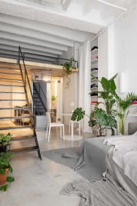 Modern industrial residential loft featuring concrete, metal, and glass elements.