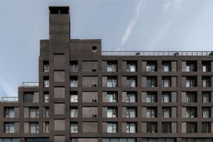 Modern apartment building with concrete and glass exterior, minimalist design.