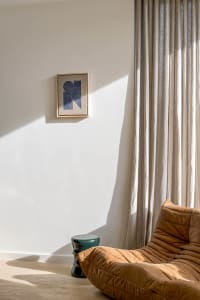 Contemporary living room with a comfortable leather couch and fabric curtains, featuring modern furniture and cozy ambiance.