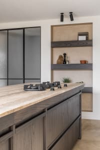 Modern residential kitchen with stained wood cabinets and stone countertops.