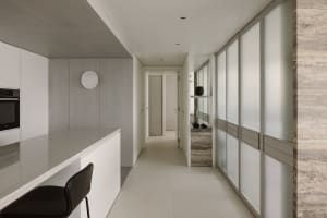 A modern minimalist kitchen featuring white materials, with an open layout and a sleek, minimalistic design.