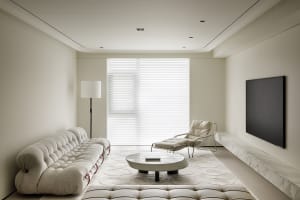 Modern living room with a white sofa, chaise lounge, round coffee table, and marble flooring.