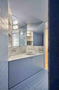 Modern minimalist bathroom with blue tiles and white marble accents