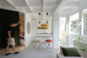 A modern, minimalist kitchen with white surfaces and an open-plan design.