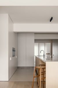 Modern minimalist kitchen with light wood elements and a sleek, clean design.