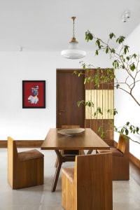 A modern dining room with wooden furniture, a wooden table, and a wooden chair.