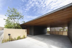Concrete driveway with wooden carport and entranceway.