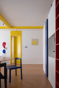 A modern residential space showcasing yellow accents on the walls and door frames.