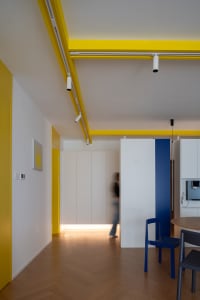 Modern white and yellow living room with metallic accents.