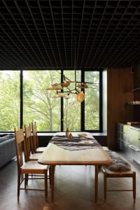 A modern dining room with a wooden table, metal chairs, and a glass chandelier.