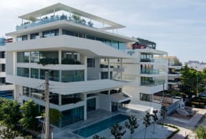Modern apartment building with concrete exterior and rooftop terrace.