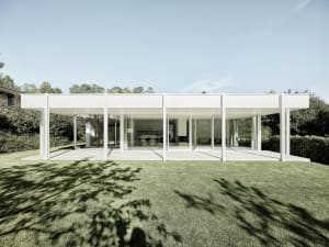 A modern residential building with white exterior, large glass windows, and a minimalist design.
