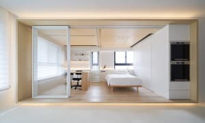 Modern minimalist bedroom with white walls, wooden floor, and minimalist furniture.