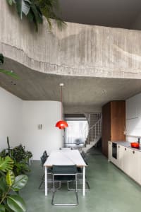 Modern concrete kitchen and dining space with minimalist design elements.