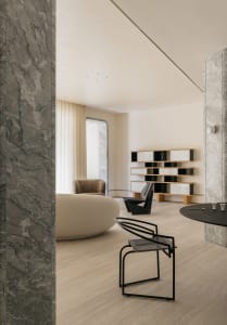 Modern living room featuring marble walls and a cozy seating area.