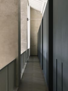 A minimalist interior design featuring a concrete cabinet and wooden shelves.