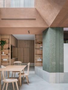 Modern minimalist kitchen featuring wood furniture, concrete countertops, and terrazzo flooring.