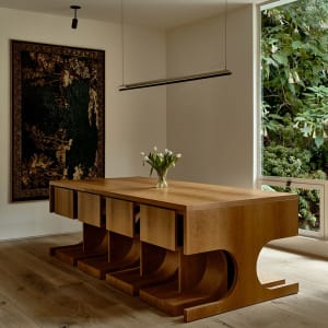 A modern residential interior featuring wooden furniture and a vase of tulips.