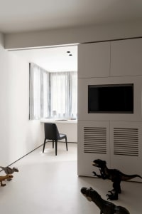 Minimalist children's room featuring a white window with sheer curtains, a black chair, and dinosaur figurines on the floor.